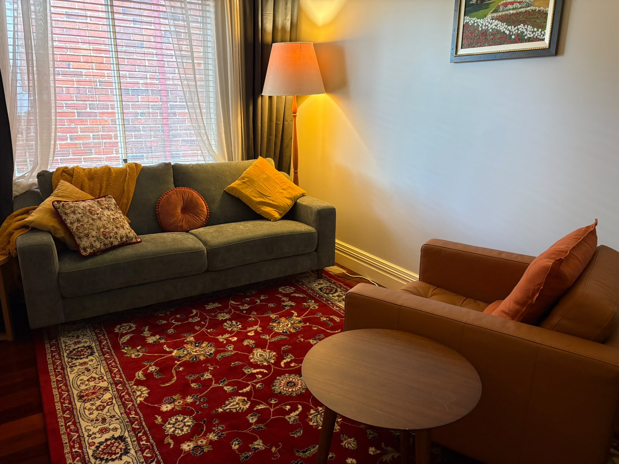 The therapy room: sofa, leather armchair and floor lamp